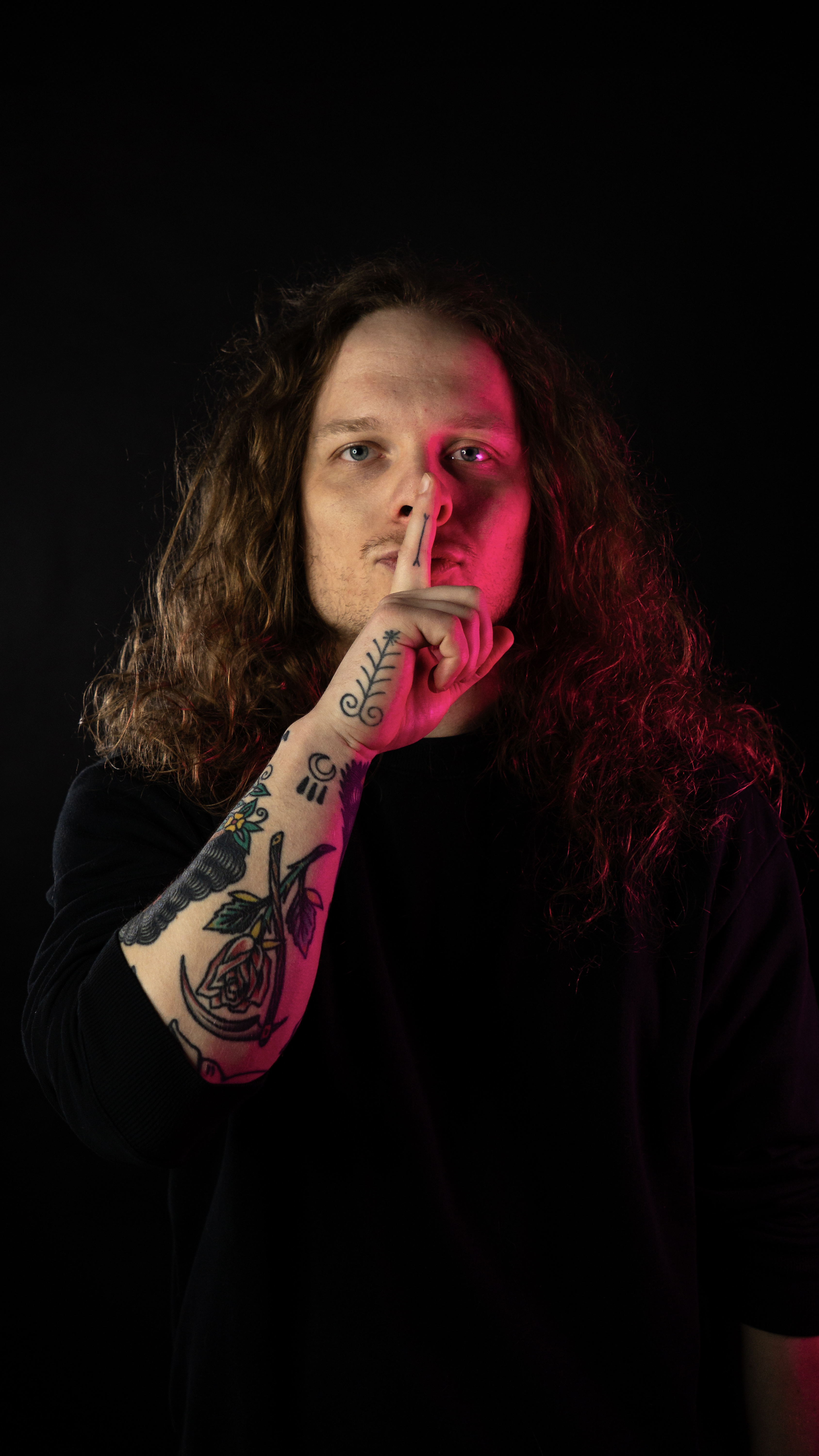 Czarek – tatuator White Rat Tattoo Warszawa, portret artysty z tatuażami na ręce w studiu tatuażu w Warszawie